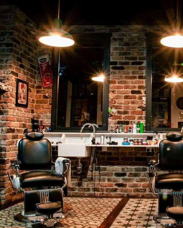 Interior da barbearia com cadeiras clássicas e espelhos